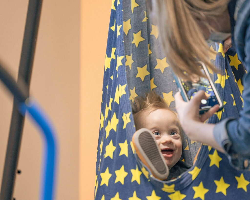 child with down syndrome in a sensory swing for sensory regulation