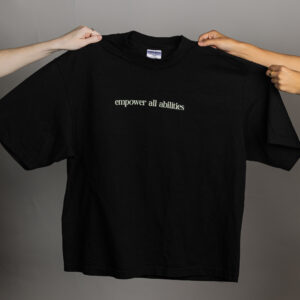 A black drop shoulder tee that says empower all abilities
